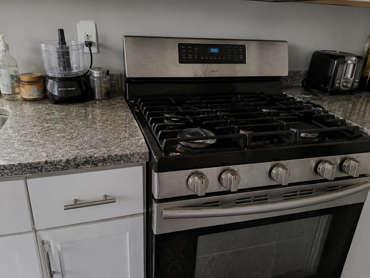 Kitchen range with grease build-up and smudged stainless steel before detailing